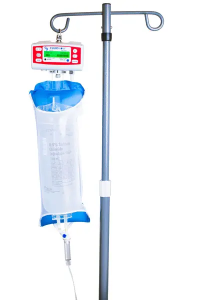 FluidNow rapid volume infuser mounted on a standard IV pole in a clinical setting, with a blue fluid bag connected and ready for patient fluid resuscitation.